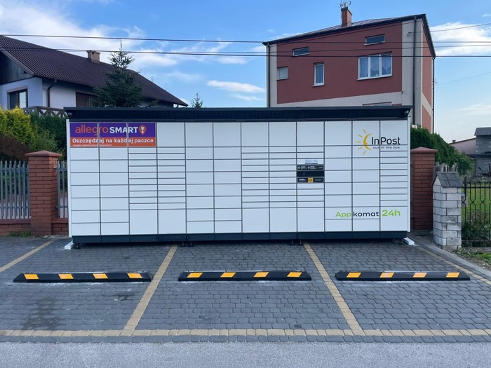 Paczkomat BUS02BAPP na parkingu przed sklepem