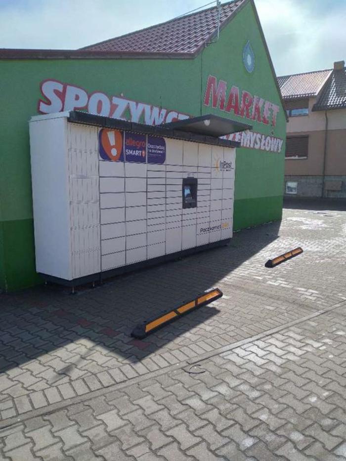 Paczkomat BXI01M przy bocznej ścianie sklepu