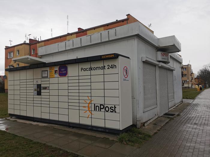 Paczkomat CCW02N Po lewej stronie od wejścia do sklepu spożywczego