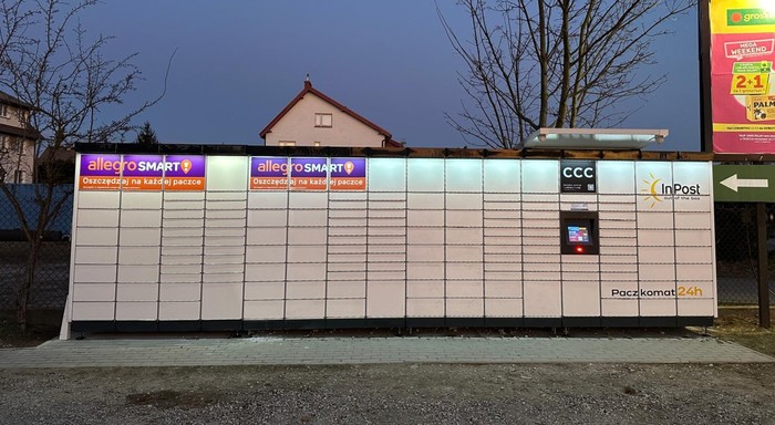 Paczkomat CIE08M Na parkingu przy sklepie Groszek.