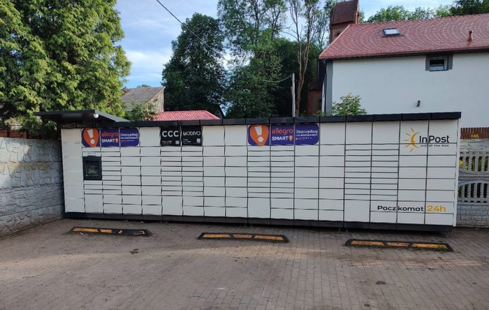 Parcel Locker CMS01M Po lewej stronie parkingu przy sklepie.