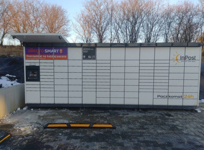 Paczkomat GMNA01M Na parkingu przed budynkiem