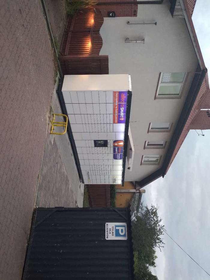 Paczkomat GOL05M Na terenie nieutwardzonej drogi prywatnej przy sklepie spożywczym