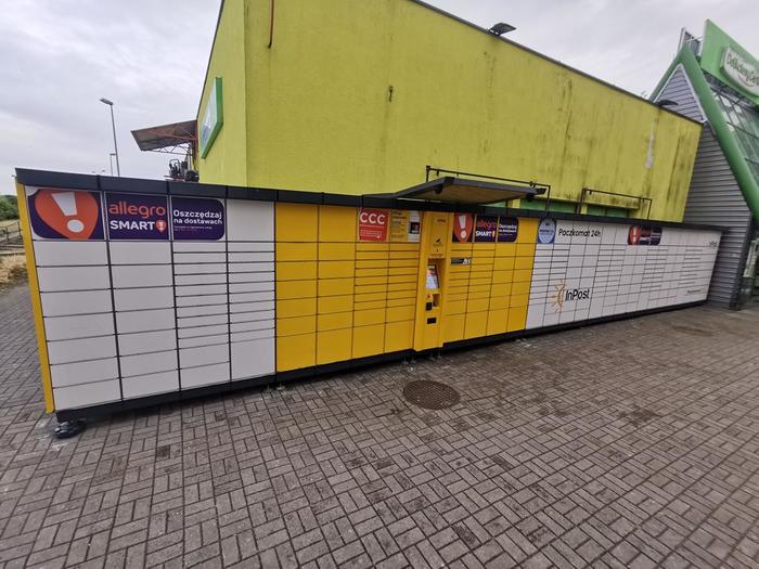 Paczkomat GRF02A Po lewej stronie sklepu Delikatesy Centrum