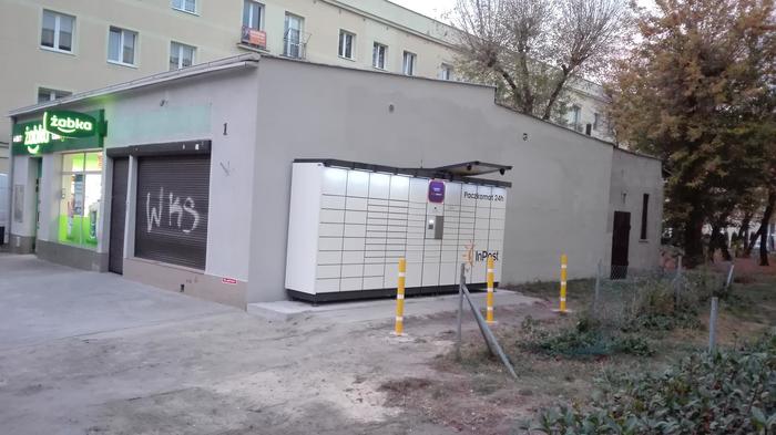 Paczkomat INO06N Przy sklepie Żabka na bocznej ścianie.