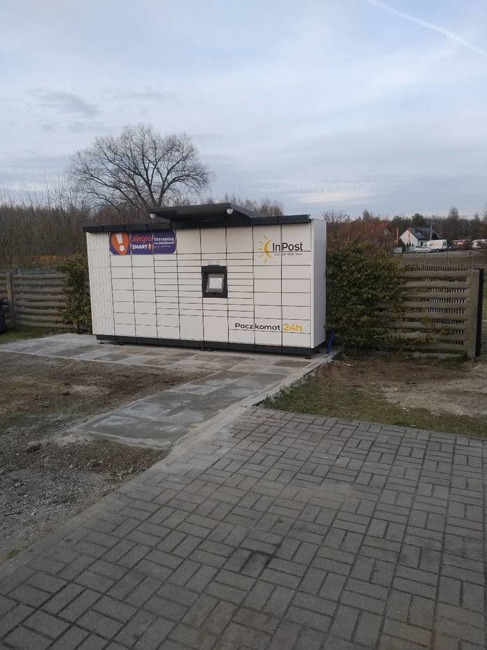 Paczkomat IZW01M Na parkingu przy sklepie spożywczym