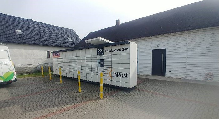 Paczkomat JAW09N Na parkingu przed sklepem spożywczym