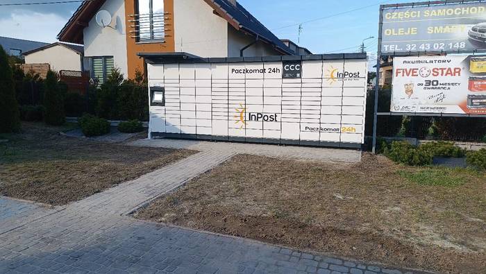 Paczkomat JEJ02M na parkingu przed sklepem z częściami samochodowymi