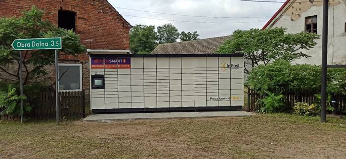 Parcel Locker JZN01M w płocie obok figurki