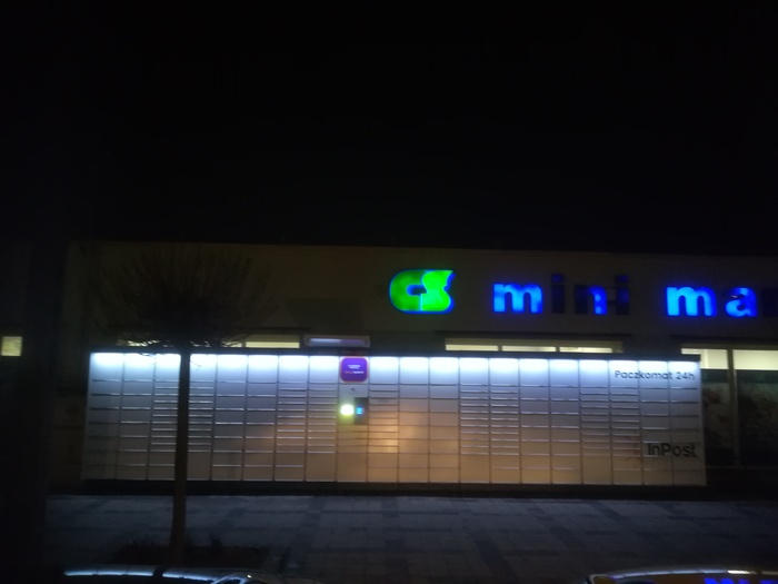 Paczkomat KBC01N Po lewej stronie od wejścia do sklepu Mini Market