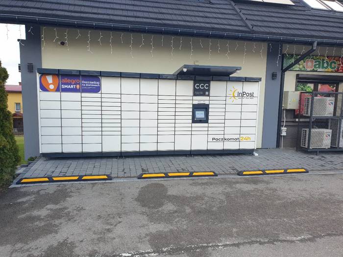 Paczkomat KNW01M Na parkingu przed sklepem