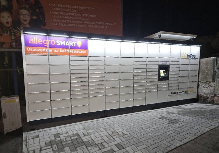 Paczkomat KPC03M Po lewej stronie od budynku.