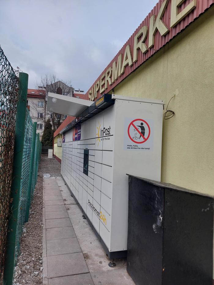 Поштомат KRA120M Z boku przy ścianie sklepu Lewiatan