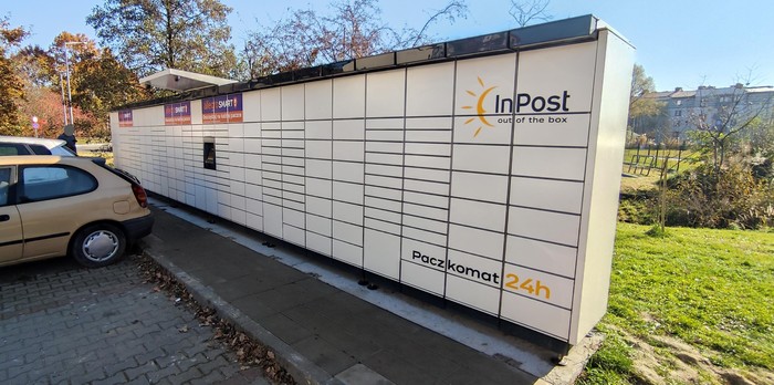 Paczkomat KRA229M Na parkingu przed budynkiem od strony pętli autobusowej