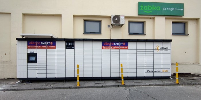 Paczkomat KRA235M przy wjeździe na parking, obok Lokali handlowych