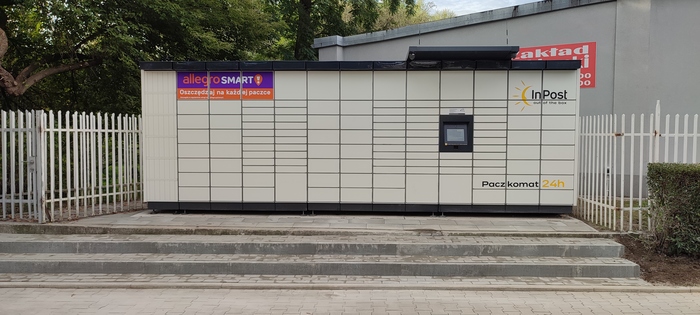 Paczkomat KRA355M Przed budynkiem biurowym na lewo od bramy wjazdowej