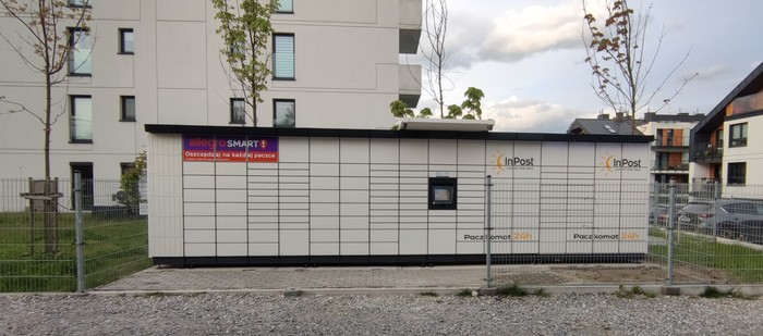 Paczkomat KRA393M Przy ulicy, obok wjazdu na osiedle