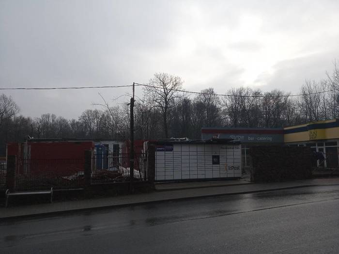 Paczkomat KRA63M Przy przystanku autobusowym, naprzeciwko szkoły