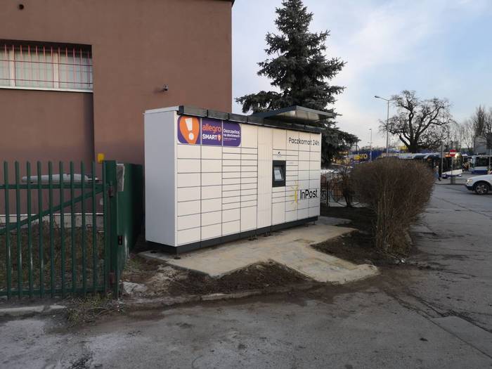 Paczkomat KRA66M na parkingu, obok sklepu Top Market