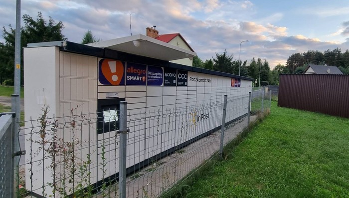 Paczkomat KRK01M Po lewej stronie od wejścia do sklepu.