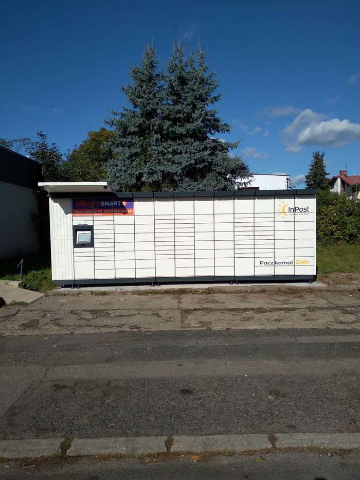 Paczkomat LEG24M Po prawej stronie przed wejściem do sklepu.