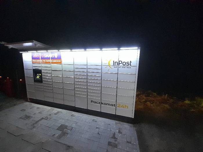 Paczkomat LIPN01M Po lewej stronie od sklepu spożywczego.
