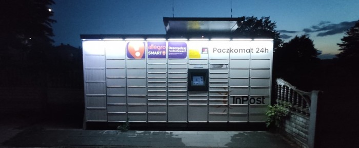 Paczkomat LKN01M Po lewej stronie od głównego wejścia do sklepu spożywczego