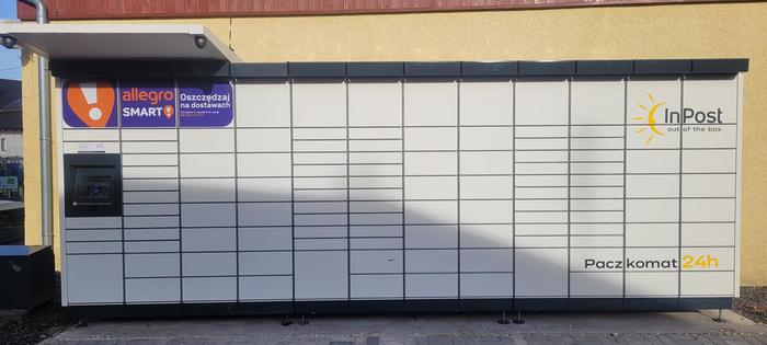 Paczkomat MKV01M Po prawej stronie od wejścia do sklepu.