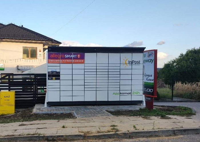 Paczkomat MOJA01BAPP Przy sklepie spożywczym przed ogrodzeniem