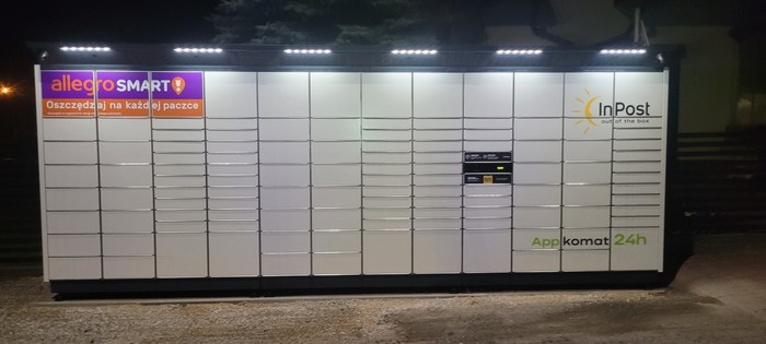 Paczkomat NITD01BAPP Przed sklepem równolegle do płotu