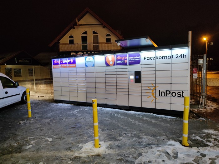 Paczkomat NSA09N Na parkingu, przy wjeździe na osiedle
