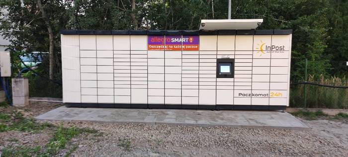 Paczkomat NSA24M przy wjeździe na parking po lewej stronie