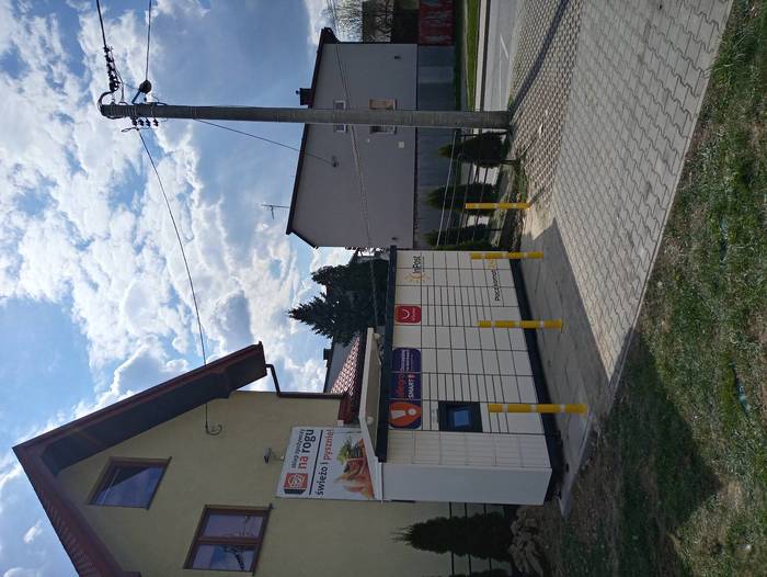 Paczkomat NTA04M na parkingu przy sklepie spożywczym