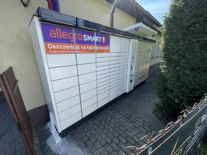 Paczkomat ODZ01A Przy ścianie domu za bramką