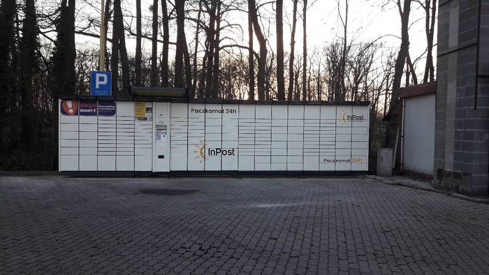 Paczkomat OPO10A Na parkingu z prawej strony od wjazdu