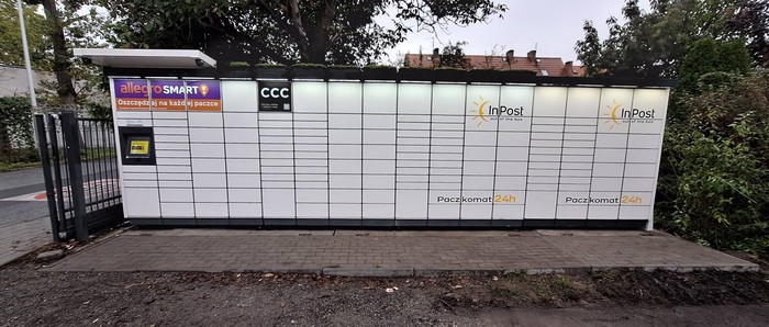 Paczkomat OPO48M Na posesji prywatnej obok sklepu spożywczego