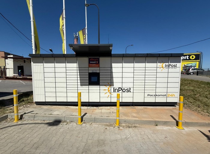 Paczkomat OPT02M Na parkingu przed sklepem RTV