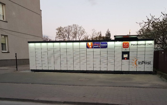 Paczkomat OSM02M Na parkingu budynku usługowego przy ulicy Kolejowej 7