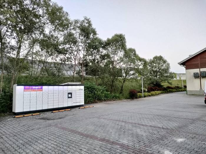 Paczkomat PCM01M Na parkingu za sklepem Delikatesy Centrum
