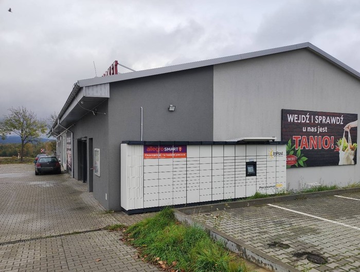 Paczkomat PJM02M przed wejściem do sklepu Robert