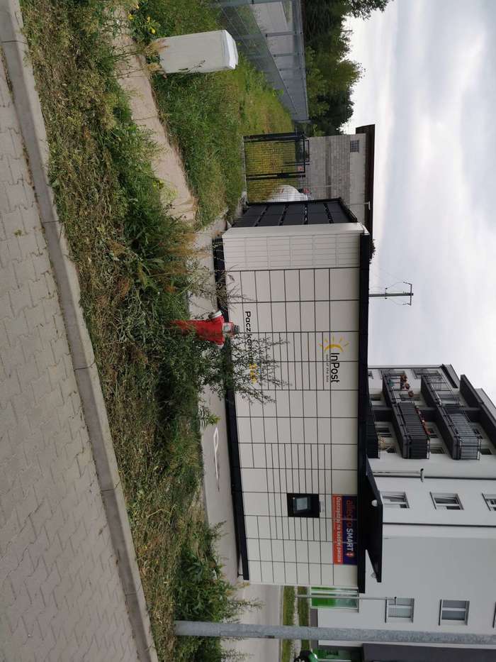 Paczkomat PLC10M Na parkingu obok wiaty śmietnikowej