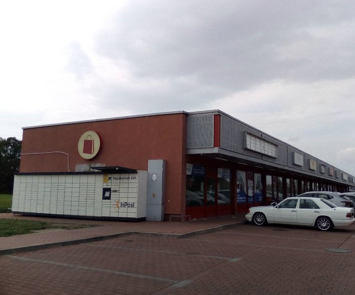 Paczkomat PRD01M Po lewej stronie budynku centrum handlowego Czerwona Torebka