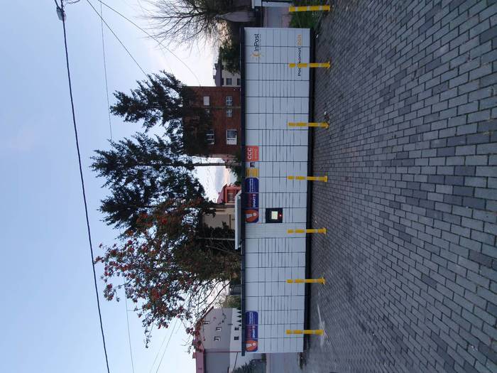 Поштомат PRO01M na parkingu przed sklepem z artykułami elektrycznymi