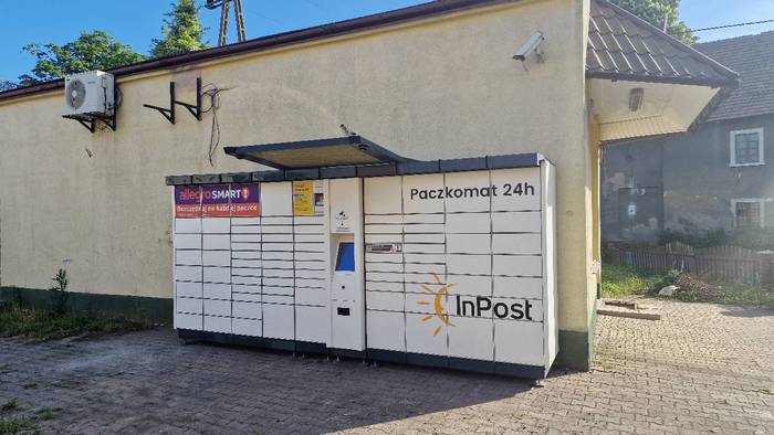 Paczkomat PRUS01A Po lewej stronie od cukierni.