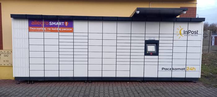 Paczkomat PTR18M Na parkingu przy sklepie spożywczym