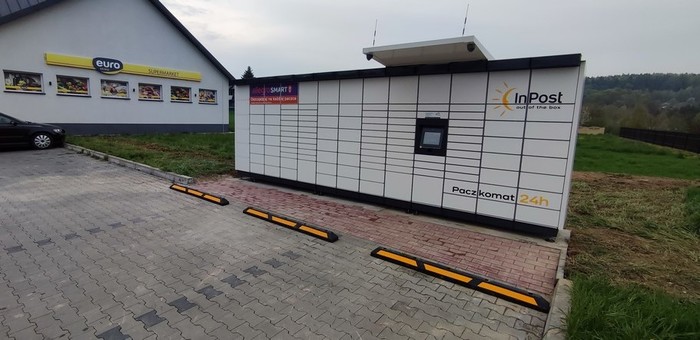 Paczkomat PZT02M na parkingu obok sklepu