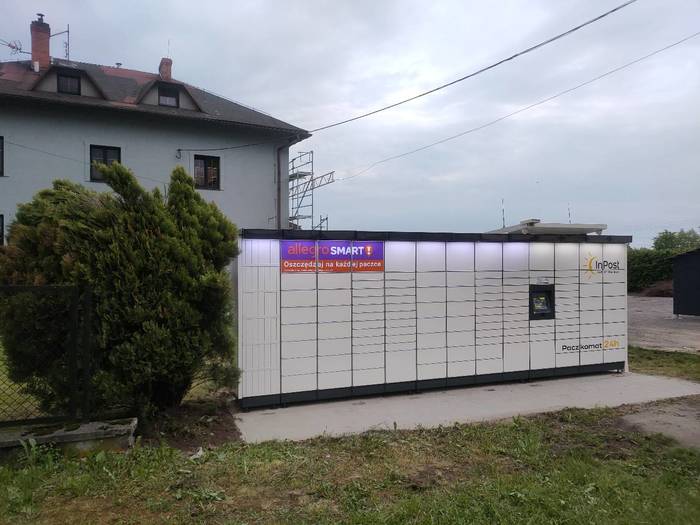 Paczkomat RUDO01M Na parkingu przed budynkiem