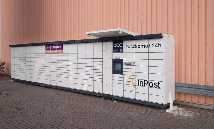 Paczkomat RUM01M Po prawej stronie od wejścia do sklepu Auchan