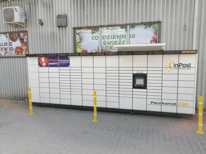 Paczkomat SES03M po lewej stronie od wejścia do sklepu