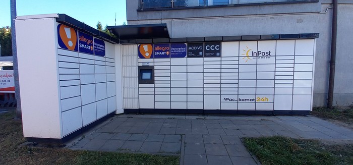 Paczkomat SIS09M plecami do ściany budynku